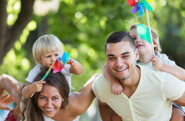 Rodzice z dziecmi trzymanymi na plecach.